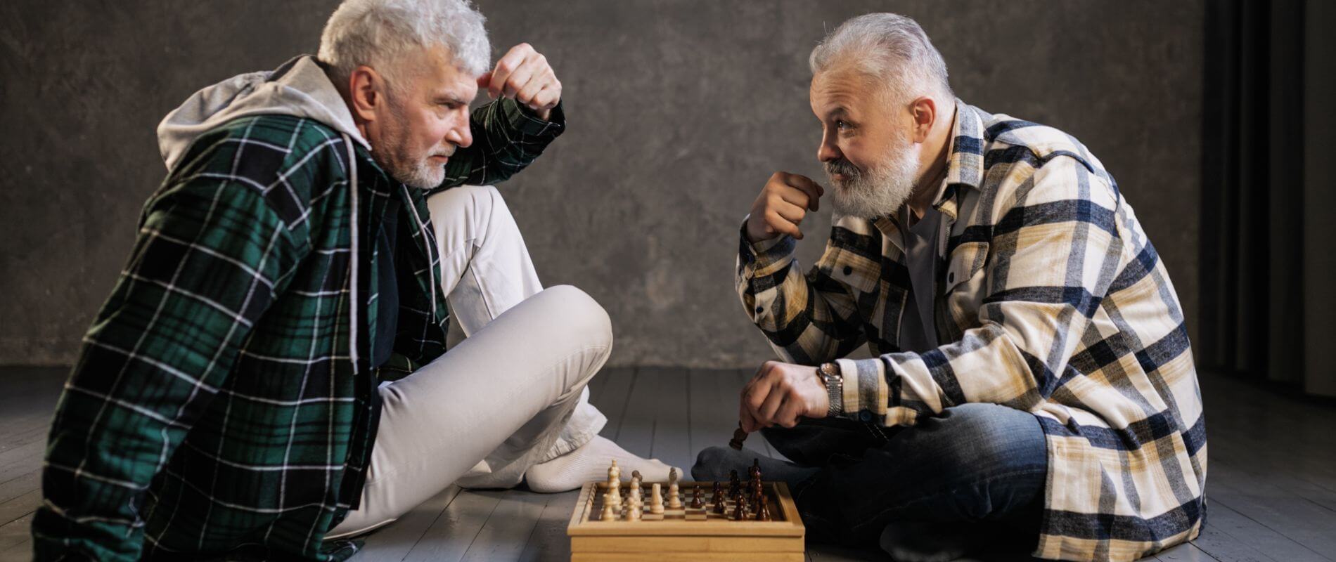 Two elderly man playing chess and discussing Medicare changes