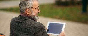 Senior man reading on tablet about Medicare